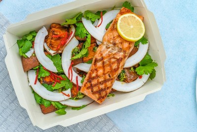 A green salad with coconut and salmon on top.